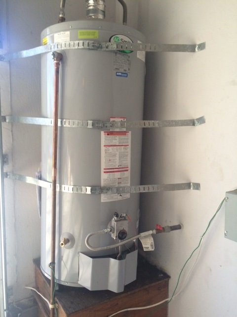Newly installed water heater strapped and fitted in a garage