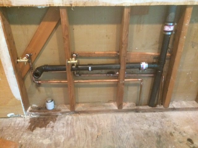 Open wall showing new copper and drain piping in framing