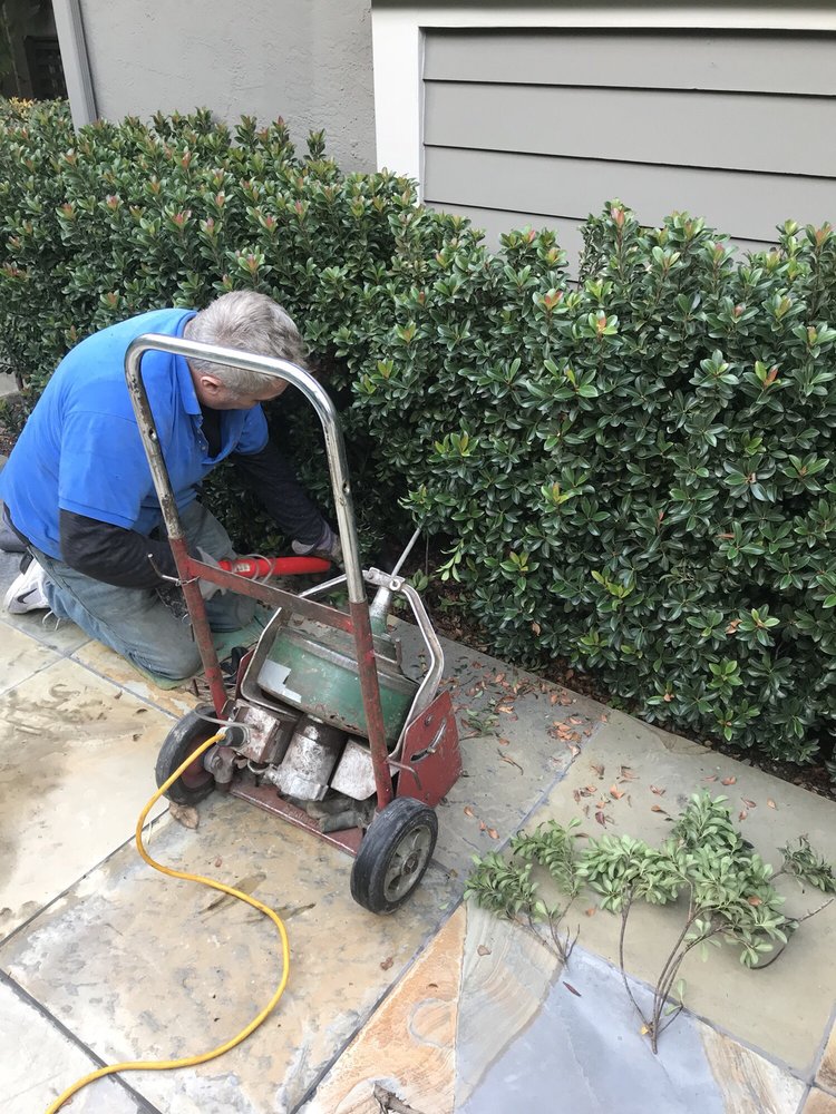 Plumber clearing a blocked line with a cable drain machine