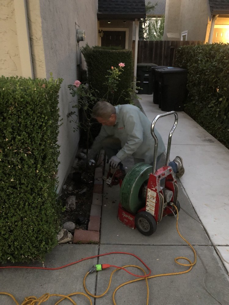 Technician running a drain machine at a side-yard cleanout